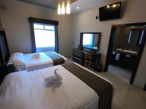 a hotel room with two beds and a bathroom at Hotel San Diego in Guanajuato