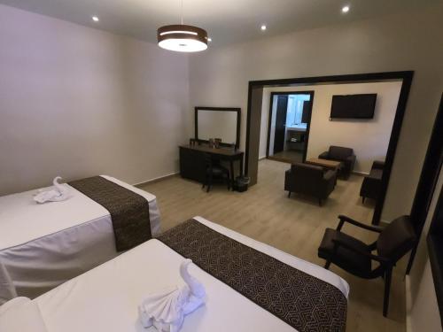 a hotel room with two beds and a mirror at Hotel San Diego in Guanajuato