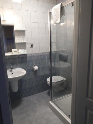 a bathroom with a toilet, sink, and mirror at Hotel Marmułowski in Wejherowo