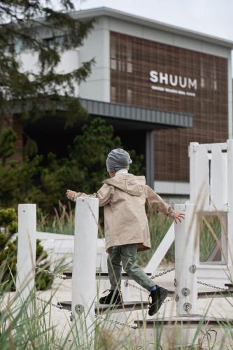a man jumping over a fence in front of a building at Hotel Shuum Boutique - Destigo Hotels in Kołobrzeg