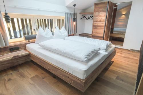 a bedroom with a large bed with white sheets at Innerbachlerhof - Mut in Postal
