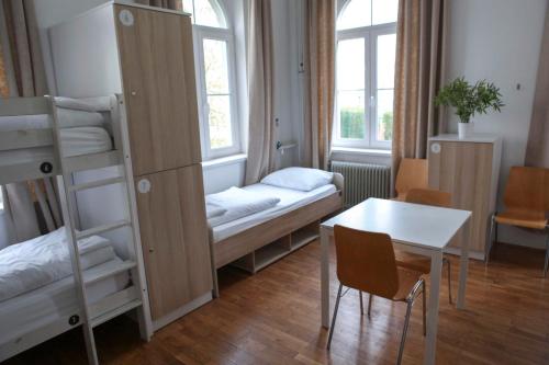 een kamer met een stapelbed, een tafel en een bureau bij Hostel DIC in Ljubljana