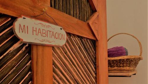un cartel en una estantería de madera con una cesta en Posada Gallinas, en Palomino