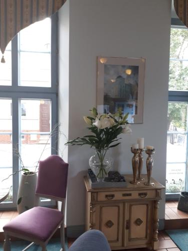 ヴェイヘロヴォにあるHotel Marmułowskiの花瓶付きのテーブルが備わる部屋