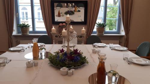 a dining room table with a vase of flowers on it at Hotel Marmułowski in Wejherowo