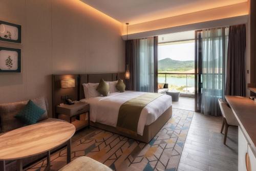 a hotel room with a bed and a table and chairs at Holiday Inn Resort Maoshan Hot-Spring, an IHG Hotel in Jurong