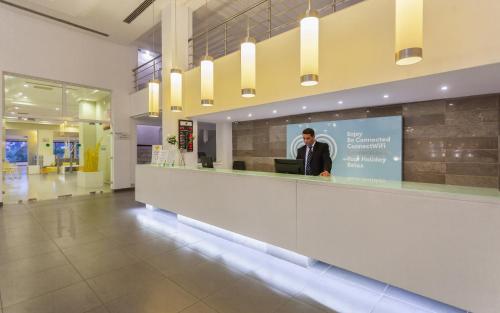 a man standing behind a reception counter in a building at Djerba Aqua Resort in Midoun