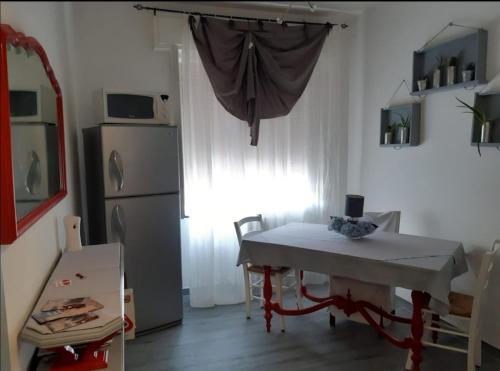 a small kitchen with a table and a refrigerator at B&B La Mandragola in Berra