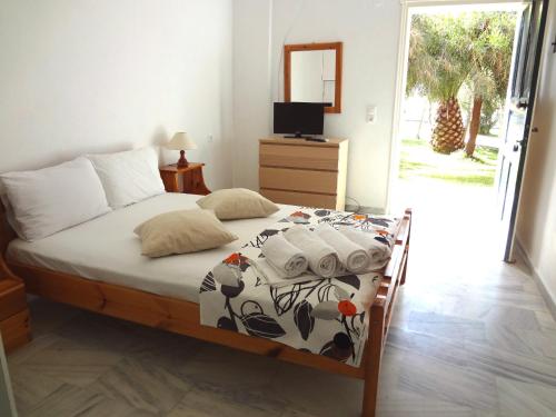 a bedroom with a bed and a television and a door at Lazaris Apartments in Agios Ioannis Lefkada in Lefkada Town