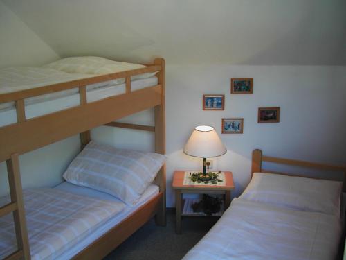 a bedroom with two bunk beds and a table with a lamp at Ferienwohnung 11 Planneralm in Planneralm