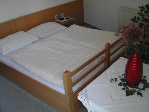 un letto con struttura in legno e un tavolo con fiori di Ferienwohnung 11 Planneralm a Planneralm