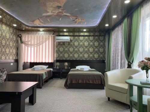 a room with two beds and a couch and a table at Mini-hotel "Lyubimyi" in Mayma