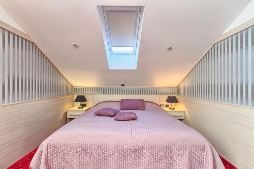 a bedroom with a bed with two purple pillows on it at Hotel Galija in Pula