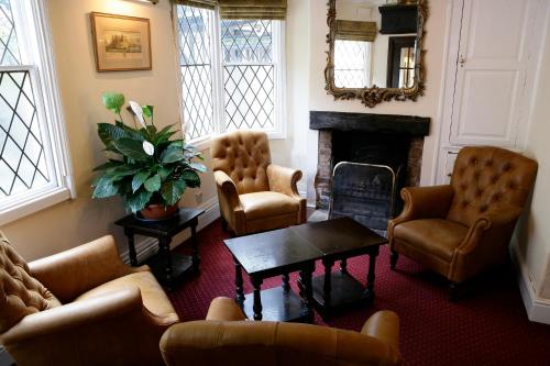 a living room with couches and chairs and a fireplace at The Saracens Head Hotel in Southwell