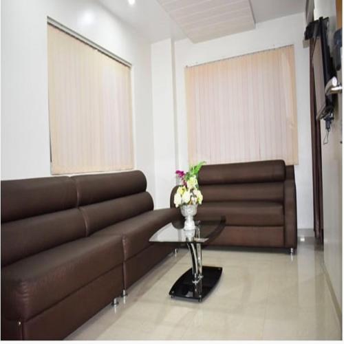 a living room with a brown couch and a table at HOTEL ANAND INTERNATIONAL in Bodh Gaya