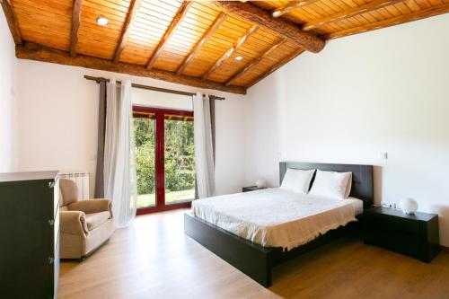 a bedroom with a bed and a large window at Casa de Fundões - Gerês in Geres