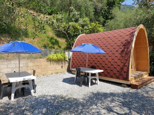 deux tables et deux parapluies à côté d'un bâtiment dans l'établissement Campeggio Gianna Golfo dei Poeti, à Lerici