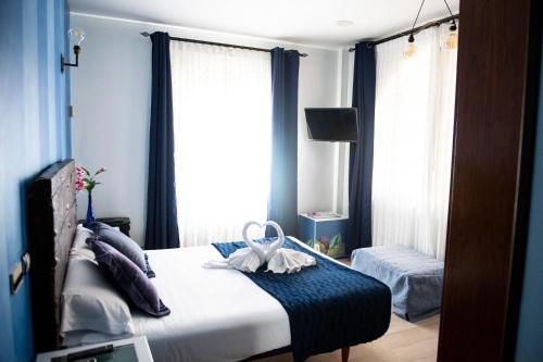 a bedroom with a bed with blue curtains and a window at Posada la Leyenda in Santillana del Mar