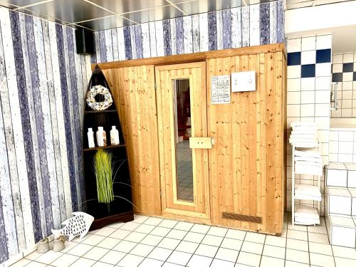 a bathroom with a wooden door in a room at Hotel Garni Rebgarten in Ravensburg