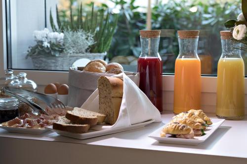 un tavolo ricoperto di piatti di pane e bottiglie di succo di B&B Le Farfalle a San Felice del Benaco
