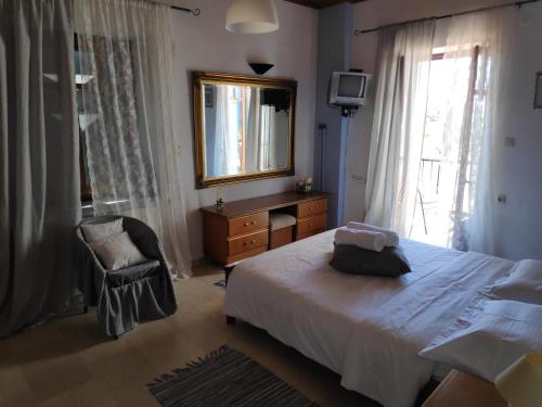 sypialnia z łóżkiem, lustrem i krzesłem w obiekcie Harbour View House w mieście Mythimna
