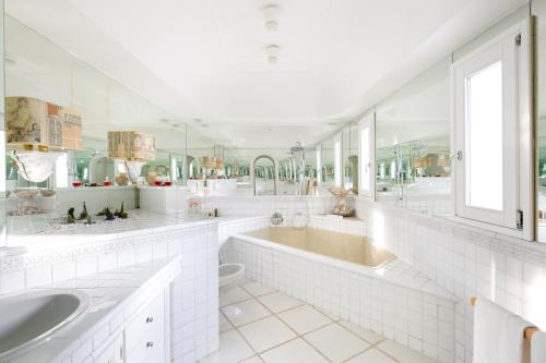 a white bathroom with two sinks and a tub at Luxury Relais Villa Magdalena in Ischia