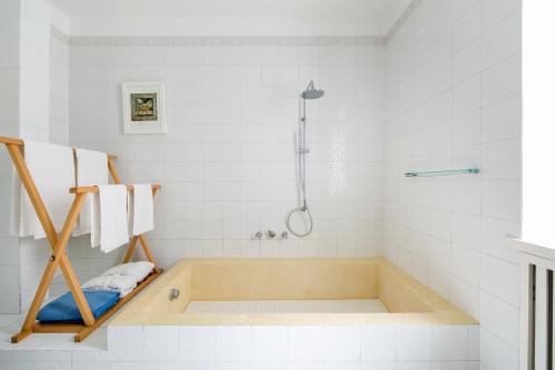a white bathroom with a tub and a shower at Luxury Relais Villa Magdalena in Ischia