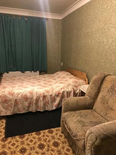um quarto com uma cama, um sofá e uma cadeira em 2к Апартаменты возле ЖД вокзала и Академии 096-55-48-111 em Khmelʼnytsʼkyy