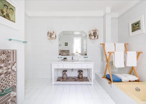 a white bathroom with a sink and a mirror at Luxury Relais Villa Magdalena in Ischia
