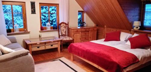 - une chambre avec un lit et une couverture rouge dans l'établissement Apartamencik na Słonecznej, à Piechowice