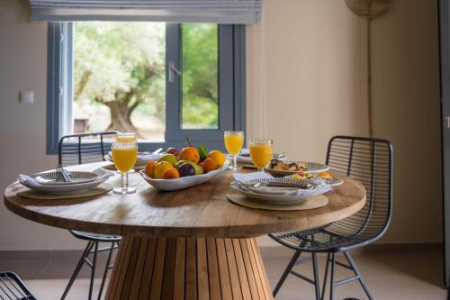 a table with a bowl of fruit and glasses of orange juice at Tree of Life in Valeriános