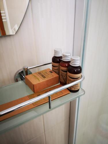three bottles of honey and a box on a shelf in a refrigerator at Brize Guest House in Tuzla