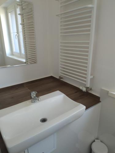 a bathroom with a white sink and a mirror at Dom gościnny Zosia in Świnoujście