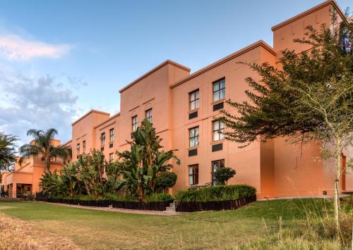 an orange building with trees in front of it at Town Lodge Polokwane in Polokwane