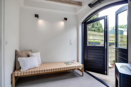 a room with a bench in front of a door at The Slow in Zuidoostbeemster