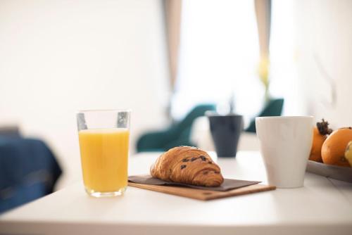 a glass of orange juice and a loaf of bread on a table at Stelle D'oro in Rovinj