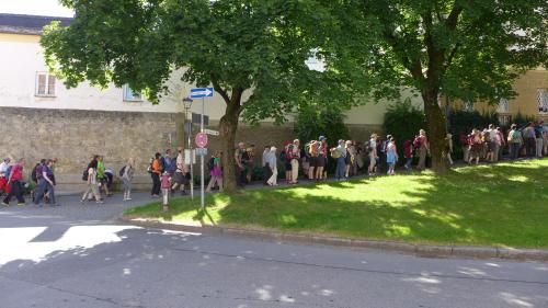 a large group of people walking down a sidewalk at Altstadthotel Schex in Altötting