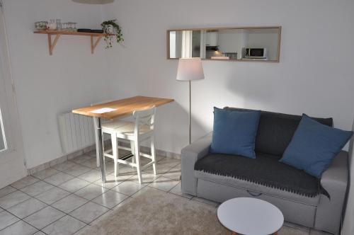 ein Wohnzimmer mit Couch und Tisch in der Unterkunft Appartement cosy refait à neuf au coeur de Saint Nazaire à 300m du front de mer in Saint-Nazaire