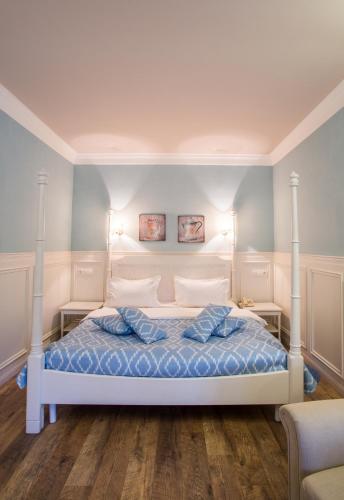 a bedroom with a white bed with blue sheets and pillows at Spa-Hotel Myslyvskiy Dvir in Kyiv