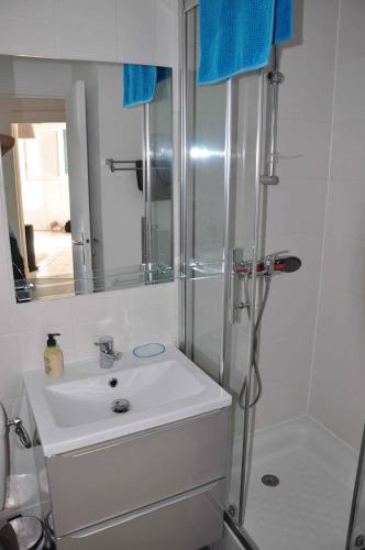 une salle de bain blanche avec une douche et un lavabo dans l'établissement Appartement cosy refait à neuf au coeur de Saint Nazaire à 300m du front de mer, à Saint-Nazaire