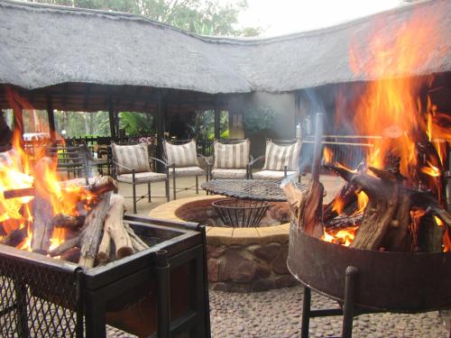 a large grill with fire in a yard at Bass Lake Country Lodge in Pretoria