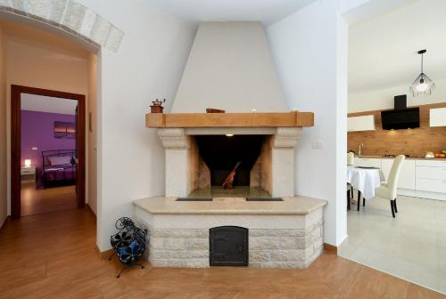 een woonkamer met een stenen open haard in een huis bij Villa Lavanda in Galižana