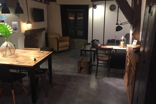 un salon avec une table et des chaises et une cuisine dans l'établissement T3 duplex industriel hyper centre ville historique, à Troyes