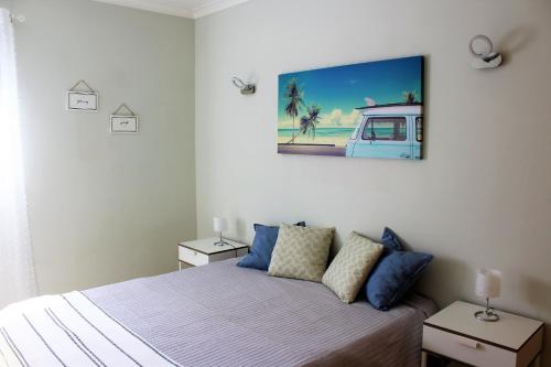 a bedroom with a bed and a painting on the wall at Sunny Vilamoura Pool Apartment- Free Parking- Fiber Wi-Fi in Vilamoura