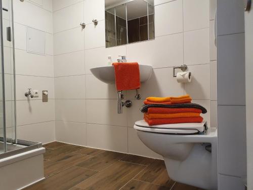 Un baño con inodoro, lavabo y toallas. en Nikolaikirch-Hof, en Wismar