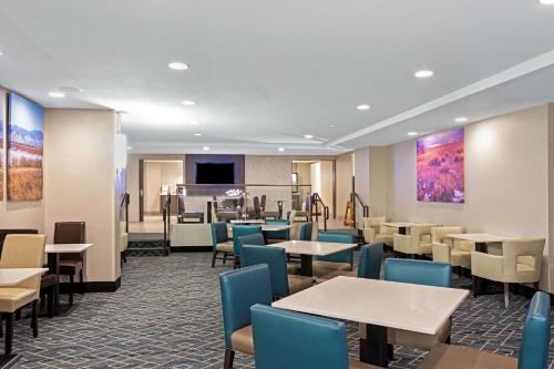 un ristorante con tavoli, sedie e un pianoforte di La Quinta by Wyndham Denver Aurora Medical ad Aurora