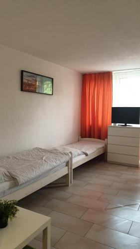a bedroom with a bed and a flat screen tv at Workers-Sleep-Station in Cologne