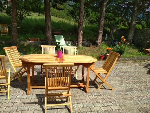 einen Holztisch und Stühle auf einer Terrasse in der Unterkunft Daphrose chambre in Lachau