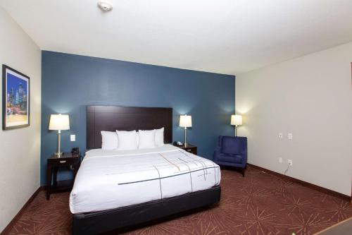 a bedroom with a large bed and a blue wall at La Quinta by Wyndham Houston East at Normandy in Houston