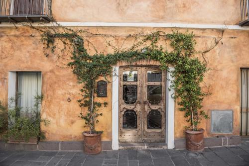 a building with a door with ivy on it at Hotel Anticos Palathos in Orosei